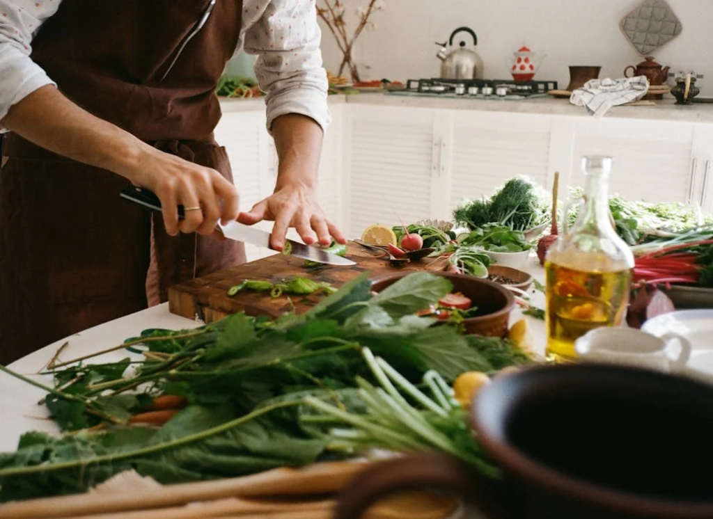 A holiday cooking class table filled with fresh vegetables, herbs, and prepared dishes